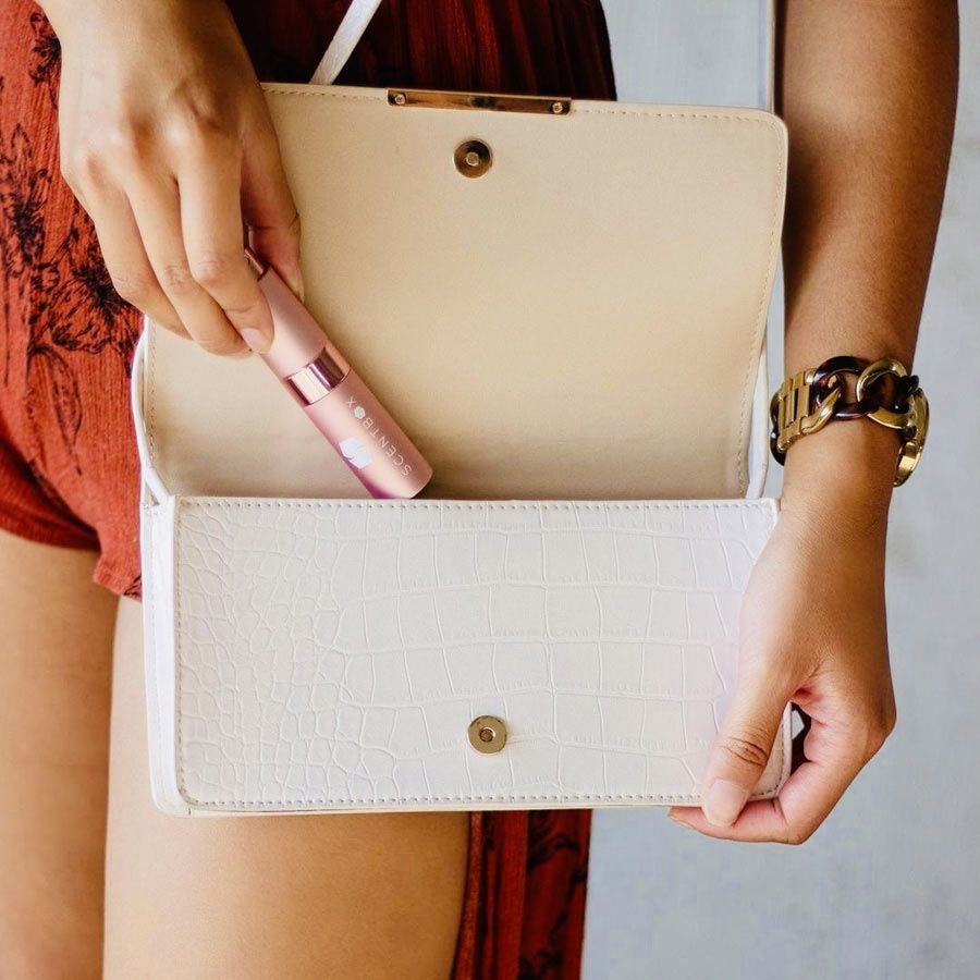 Happy ScentBox subscriber with collection of designer fragrance vials from monthly subscription service